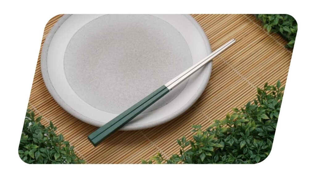 Ladata Green BaoQuai Chopsticks on a white plate.
